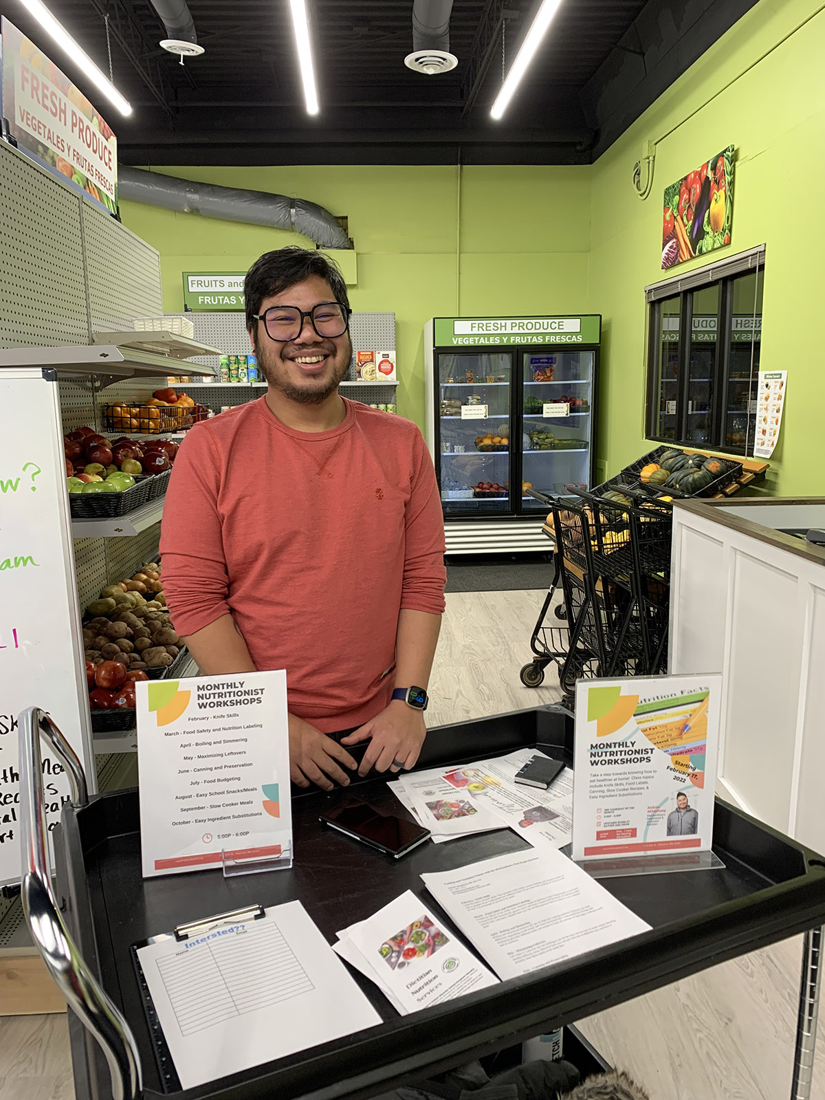Andrew Akhaphong is a registered dietitian nutritionist for Mackenthun’s Fine Foods standing at a table at Gather & Grow